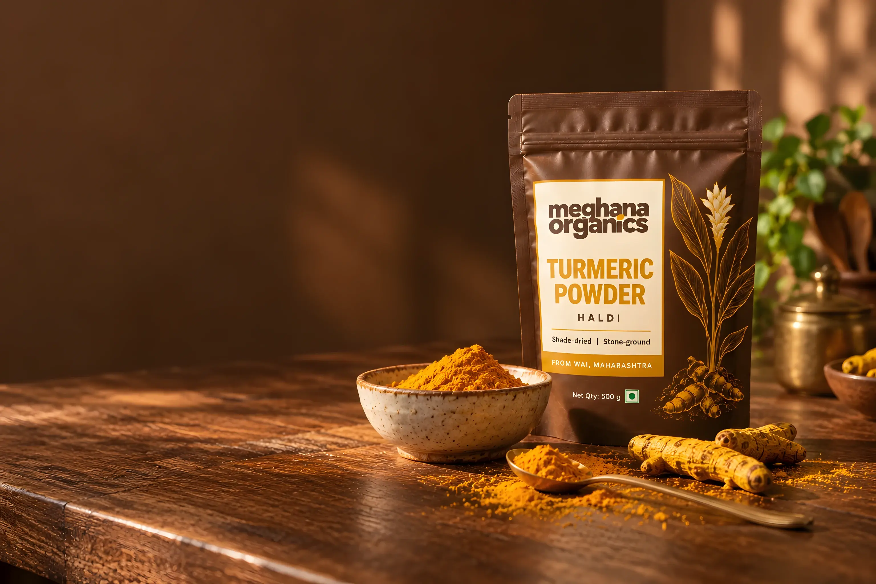 Meghana Organics turmeric powder pouch on a wooden table with a bowl of haldi